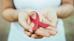 Hände mit roter Aids-Schleife