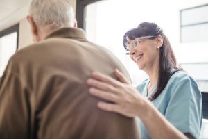 Smiling nurse assisting senior man in hospital